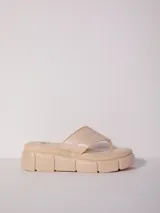 Sandalia tipo ojota con plataforma dentada de 3.5 cm de alto. Presenta una tira ancha acolchada en el empeine y una tira separadora para el dedo. La plantilla es acolchada.