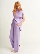 Pantalón de lino color lila, tiro alto, corte palazzo con elástico en la pretina, bolsillos laterales y dobladillo invisible.