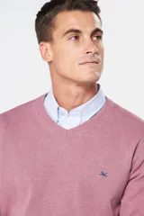 Suéter de tejido fino color azul marino, con cuello en V y manga larga. Presenta un pequeño logo bordado en el pecho.