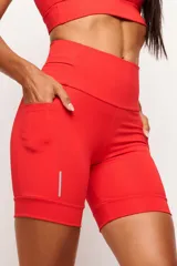 Short tipo biker de tiro alto, diseñado para running y entrenamiento. Confeccionado en tejido técnico de alta performance con bolsillos laterales funcionales y bolsillo interno en la cintura. Presenta detalles reflectivos y costuras estratégicas para mayor libertad de movimiento.