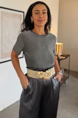 Remera elastizada gris de manga corta con cuello redondo, cubierta de apliques brillantes en toda su superficie.
