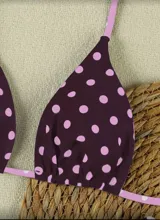 Conjunto de bikini blanco con estampado de lunares negros. El corpiño es de corte triangular con tirantes finos y la bombacha es de corte clásico.