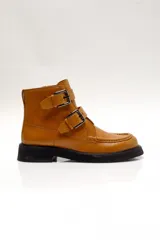 Bota corta color marrón de cuero, con puntera redondeada, suela de goma negra y cierre con cremallera lateral y doble hebilla.