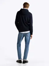 Buzo Tommy Hilfiger de felpa de algodón color azul marino, con capucha ajustable con cordón, bolsillo tipo canguro, puños y bajo de punto canalé, y logo bordado en el pecho.