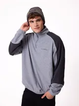 Gorro tipo beanie de punto en color gris, con franjas horizontales en verde y blanco, y logo de la marca Rusty en el frente.