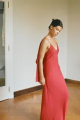 Vestido largo de georgette color rojo, con escote en pico, tirantes finos y detalle de capa fluida integrada en la parte superior.