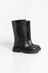 Bota de caña media confeccionada en cuero negro, con suela track de goma dentada y puntera redondeada.