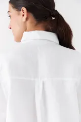 Camisa clásica blanca de manga corta, con cuello camisero y cierre frontal de botones.