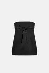 Vestido mini satinado negro con escote palabra de honor y detalle de lazo en el frente.