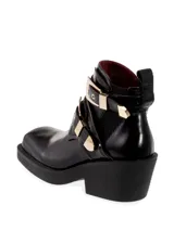 Botinetas de cuero negro con elástico en los laterales, punta cuadrada, taco ancho y detalles de hebillas doradas.