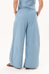 Pantalón de pierna súper amplia, confeccionado en denim fino y liviano, de tiro alto, con cintura elastizada, lazo regulable y bolsillos laterales.
