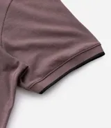 Camisa polo de manga corta confeccionada en algodón, con cuello en V y detalles en color contrastante en el cuello y los puños. Presenta un diseño de tejido en media malla, ofreciendo una textura suave y transpirable.