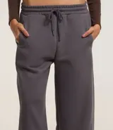 Pantalón de jogging marrón de algodón con forro de polar, corte amplio tipo barrel, cintura elástica con cordón de ajuste y bolsillos laterales.