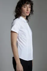 Camisa blanca de corte clásico, con cuello camisero, mangas cortas y cierre frontal con botones.