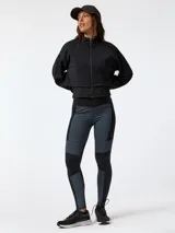 Canguro negro con cremallera, confeccionado en tejido con tecnología Aloe Vera, cuello alto y mangas largas con puños ajustados. Presenta un diseño corto con chaleco incorporado elástico y ajustable en la cintura.