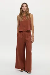 Pantalón de pierna ancha confeccionado en lino color ladrillo, con cintura elástica y cordón ajustable.