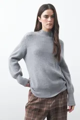 Polera de tejido de punto en color marrón oscuro, con cuello alto y diseño de silueta relajada.