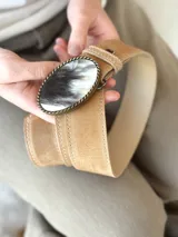 Cinto de cuero color camel con forro de cuero y hebilla ovalada con diseño de guampa.