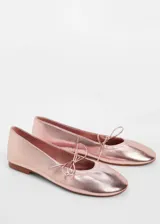 Zapato tipo bailarina con acabado metalizado en tono rosado, punta redonda y detalle de lazo decorativo en el empeine.