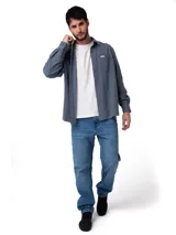 Camisa de manga larga con textura tipo waffle, color gris azulado. Presenta cuello camisero, cierre frontal con botones perlados, puños abotonados y un bolsillo en el pecho con etiqueta de la marca.