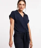 Blusa azul marino de viscosa con cuello solapa, abotonado delantero, mangas cortas con doblez y lazo en la parte baja.