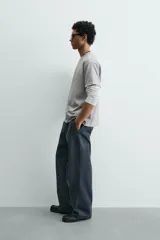 Camiseta de corte boxy fit, con cuello redondo y manga corta. Presenta un acabado irregular con efecto lavado que le otorga un aspecto vintage.