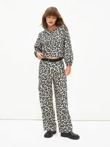 Pantalón negro de tiro alto con cintura elástica y pretina plateada brillante. Diseño ancho y holgado, estilo cargo con bolsillos laterales grandes.