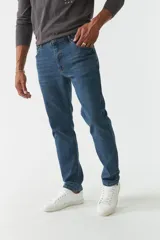 Pantalón de jean azul de corte recto, tiro medio y efecto lavado. Confeccionado en 98% algodón y 2% spandex. Cuenta con pasacintos.