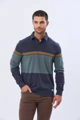 Remera polo de manga larga con diseño de bloques de color horizontales en tonos azul, verde y marrón. Presenta cuello clásico, cierre frontal con botones y bordado en el pecho. Cuenta con puños elásticos acanalados.