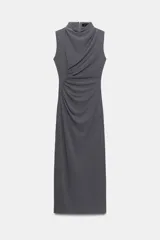 Vestido midi gris oscuro sin mangas, con cuello subido y detalle de drapeado lateral que cruza el frente. Cuenta con cierre en la espalda con cremallera oculta.