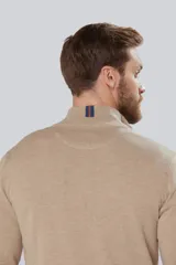 Buzo liso de punto fino en hilo de algodón color azul marino, con cuello alto y cierre frontal parcial con detalle de tirador de cuero.