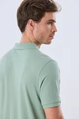 Remera polo de piqué de algodón color azul, de manga corta, con cuello camisero, cierre frontal de dos botones y pequeño logo bordado en el pecho.