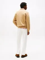 Buzo color beige de Tommy Hilfiger, de cuello redondo y corte clásico. Presenta el logo de la marca bordado en el pecho.