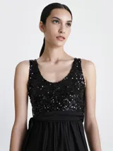 Vestido largo de fiesta negro, con top de lentejuelas y falda larga de corte recto.