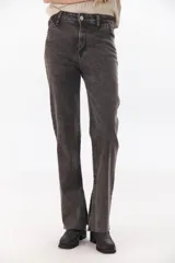 Pantalón de jean gris oscuro, de corte recto, tiro alto y tajos laterales en el ruedo.