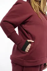 Campera deportiva oversize con capucha, cierre metálico frontal y bolsillos laterales. Presenta mangas raglán con volumen pronunciado y puños largos acanalados. Confeccionada en felpa de algodón, con cordones regulables a tono y terminaciones metálicas.