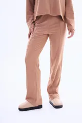Pantalon de felpa color beige, de corte recto y tiro medio, con costuras verticales decorativas en el frente.
