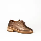 Zapato acordonado estilo oxford de cuero vacuno en color plateado metalizado, con diseño brogue, suela de goma y taco de madera.