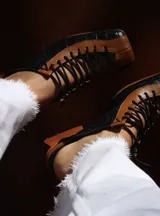 Zapato de cuero negro y marrón con cordones, detalle de textura símil cocodrilo y taco de madera.