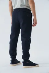 Pantalón de jogging gris melange, corte recto, con bolsillos laterales y logo en grifa de goma.