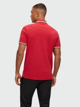 Remera polo de algodón color gris oscuro, marca Boss, modelo Paddy. Corte regular fit, cuello y puños con ribete doble en blanco y gris. Logo bordado en el pecho.