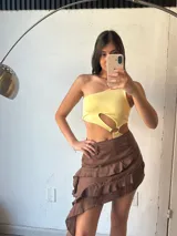 Body amarillo de un hombro con abertura en la cintura y aro metálico.