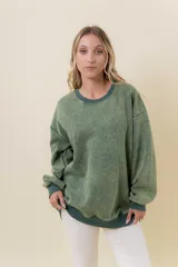 Buzo de tejido suave con lavado efecto vintage, color verde musgo, de calce oversize y cuello redondo.