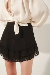 Minifalda color crema con bordado floral, cintura alta y volados en el ruedo.