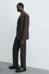 Pantalón de corte recto confeccionado en tejido con lana, color beige. Presenta bolsillos frontales, bolsillos traseros de vivo y cierre frontal con cremallera y botón.