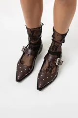 Chatas de cuero con punta fina, tira en el empeine con hebilla doble y tachas plateadas. Incluye una tira trasera con tachas. Disponibles en negro y marrón.