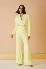 Blazer color amarillo con doble cierre dorado en la parte inferior.