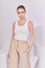 Pantalón recto color beige con cintura elástica y cierre metálico.