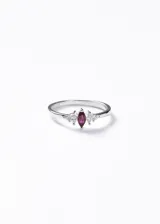 Anillo de plata 925 con diseño delicado, presenta una piedra central en forma de marquesa color rojo flanqueada por dos pequeñas zirconias a cada lado.