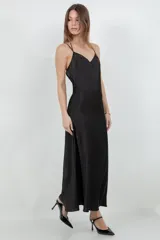 Vestido largo tipo slip dress confeccionado en tela satinada color negro, con escote en V y breteles finos.